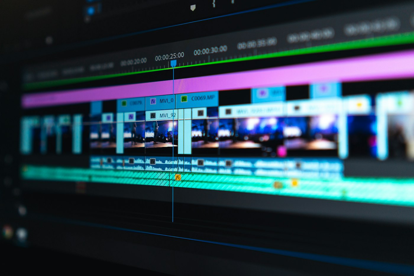 Close-up of a video editing timeline, coloured clips lined up on dark tracks.